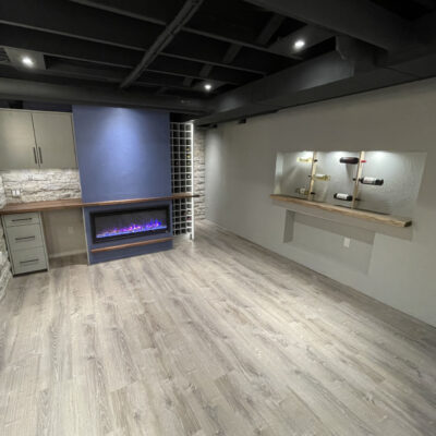 Basement renovation wine rack and fireplace view